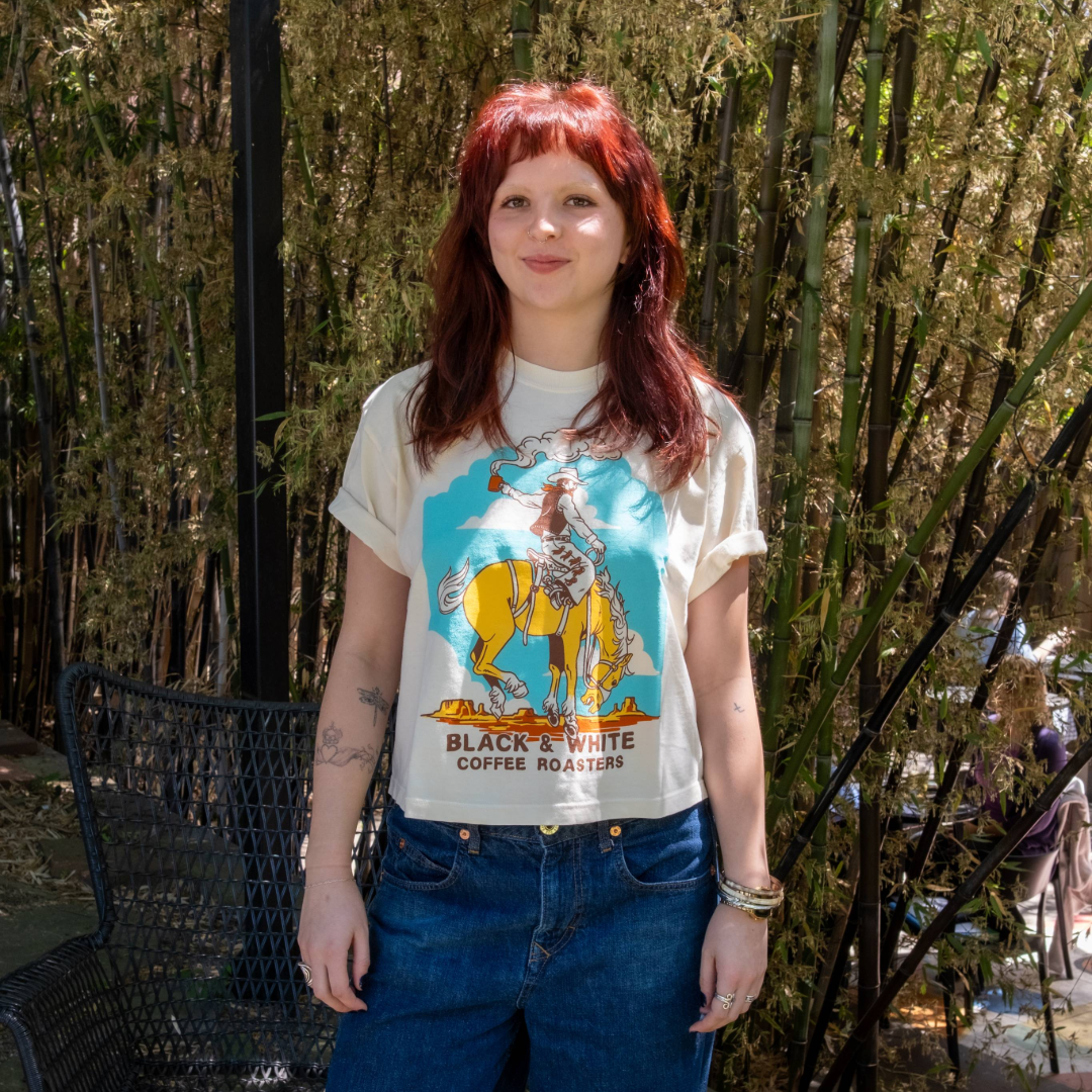 Person wearing a graphic t-shirt with a cowboy design outdoors