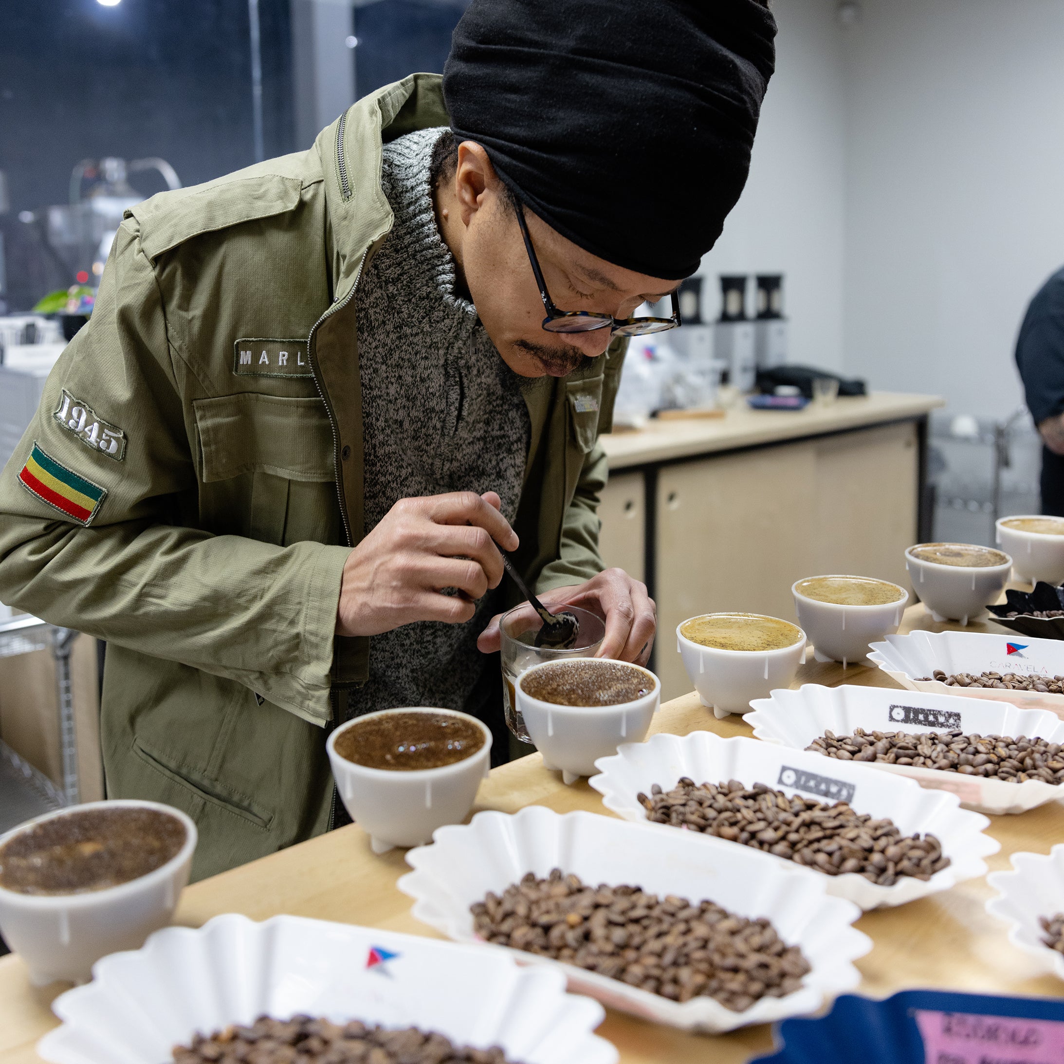 A  man cupping coffee in a modern cupping lab.