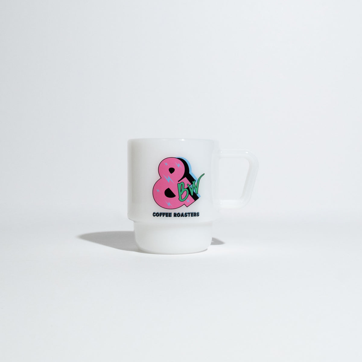 A white ceramic coffee mug with a pink ampersand and green strawberry graphic, with the text 'COFFEE ROASTERS' printed below, set against a clean white background.