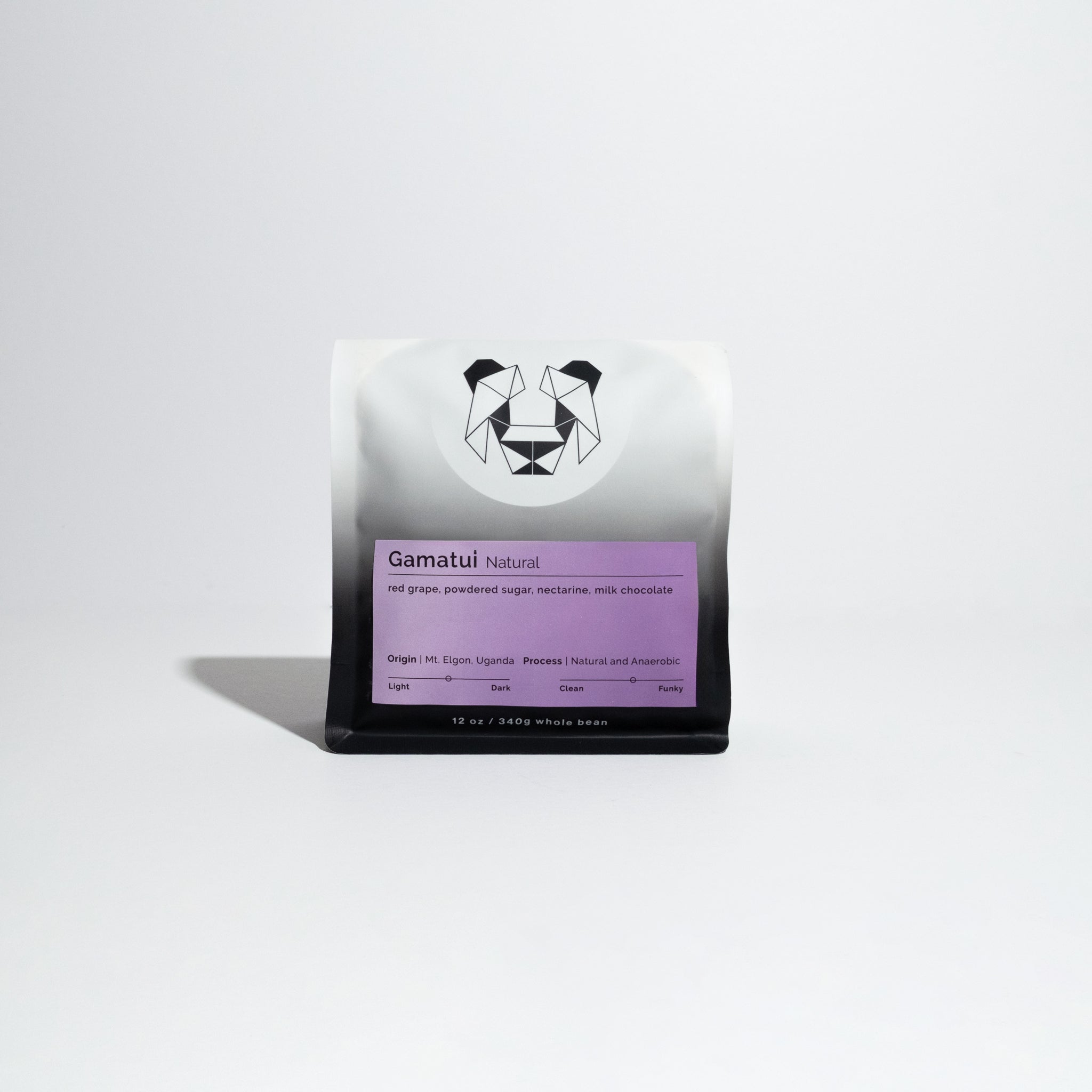 Close-up of a white and black bag labeled Gamatui - Natural featuring a panda logo, representing a specialty coffee from the Gamatui community in Uganda.